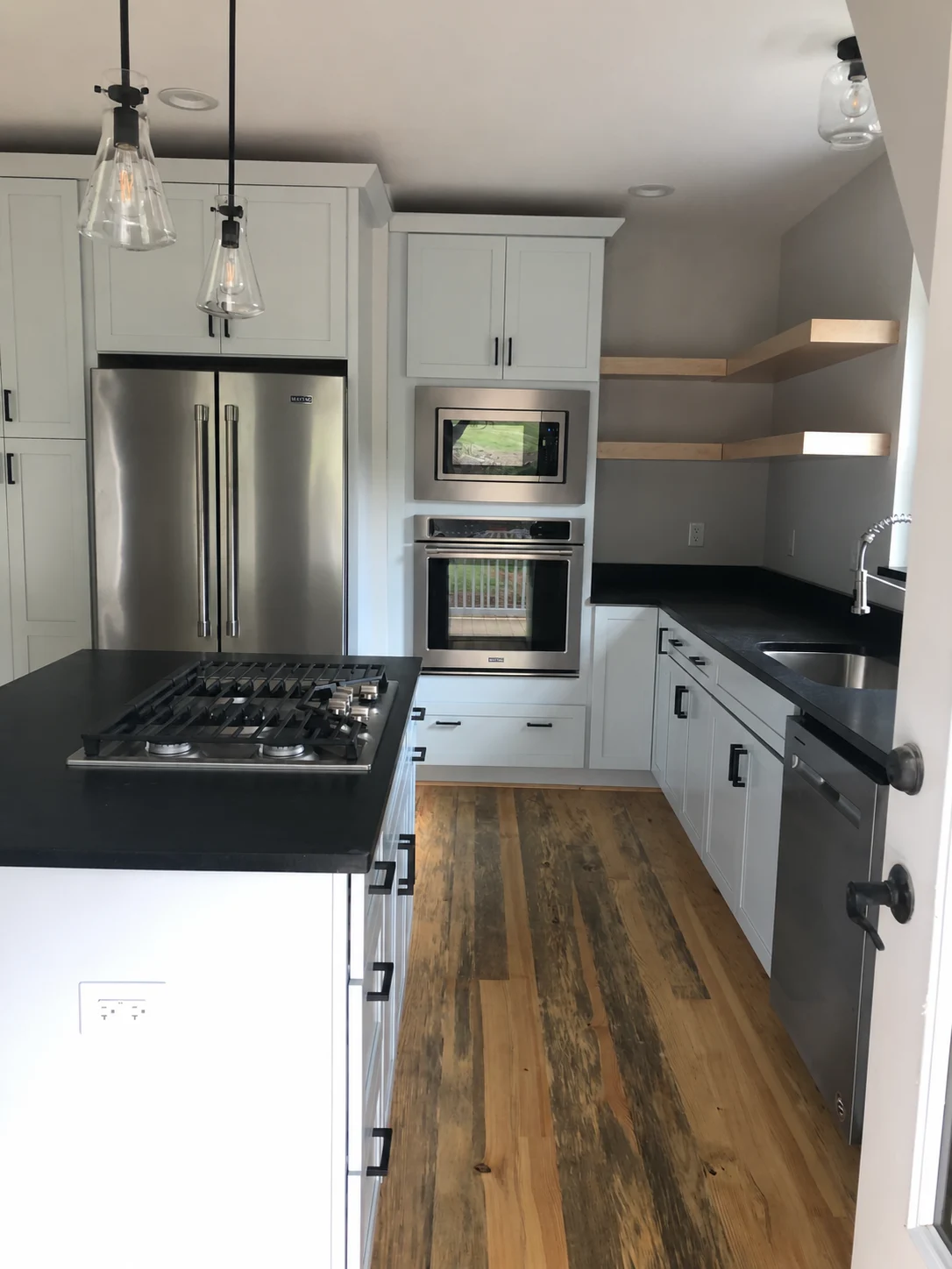 Kitchen with white cabinets and dark countertops